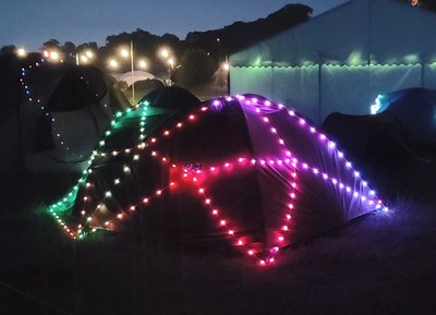 A tent covered in lights, in the late evening